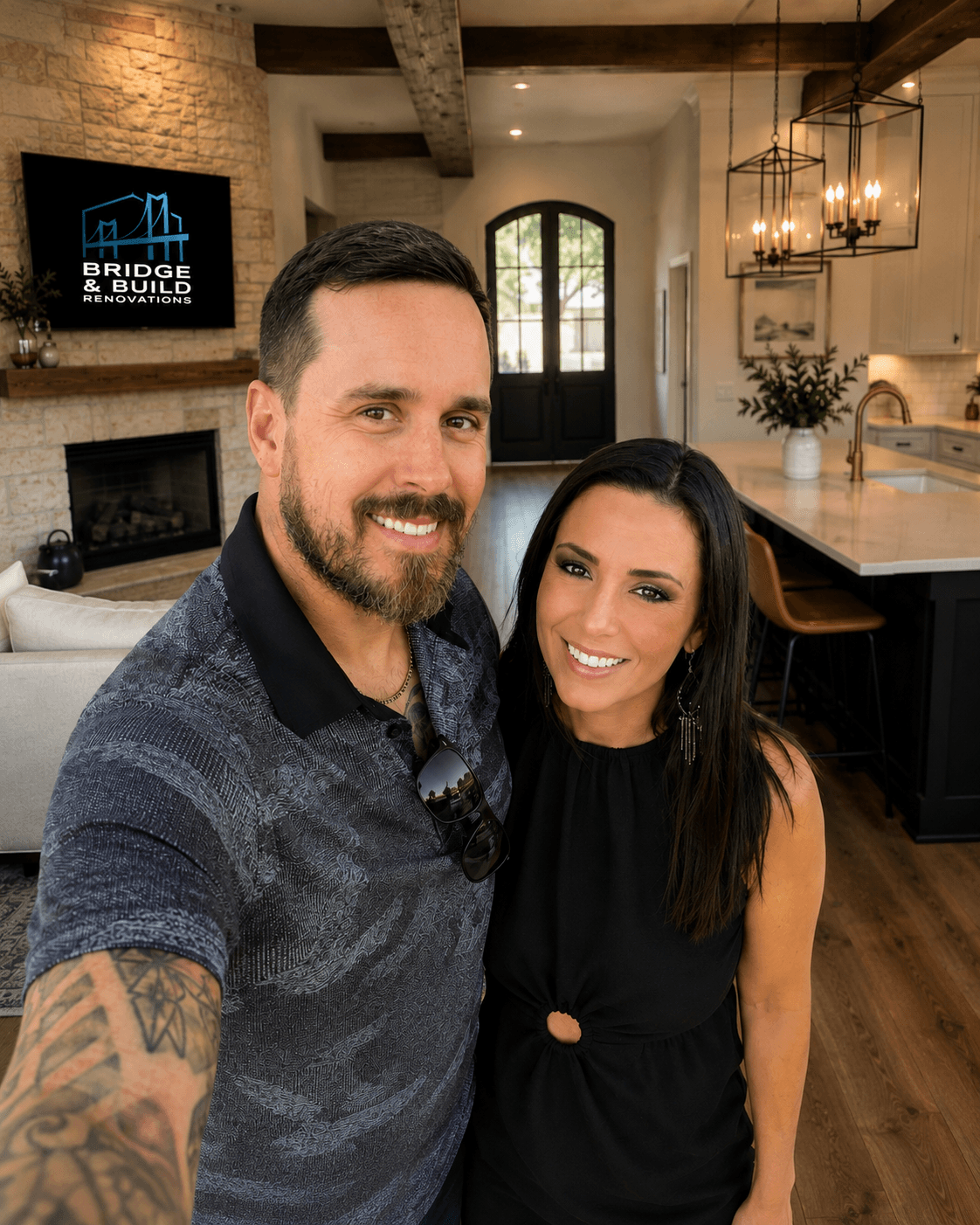 Smiling couple taking a selfie in a modern renovated home with a stone fireplace.