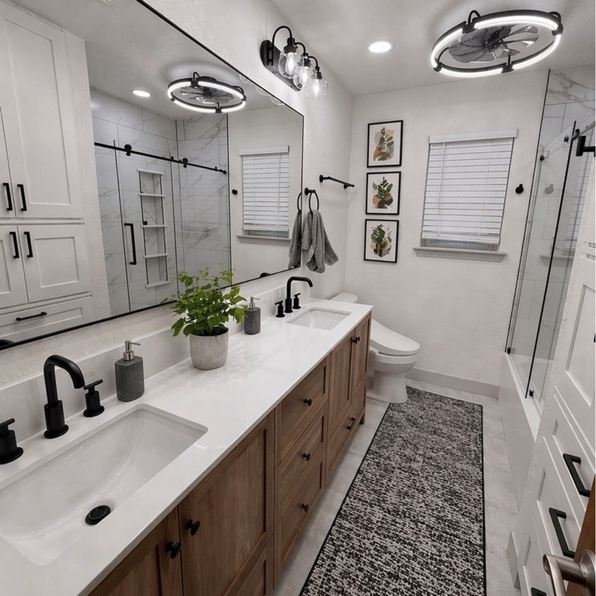 Modern bathroom with wood double vanity, black fixtures, large mirror, and circular ceiling fan lights.